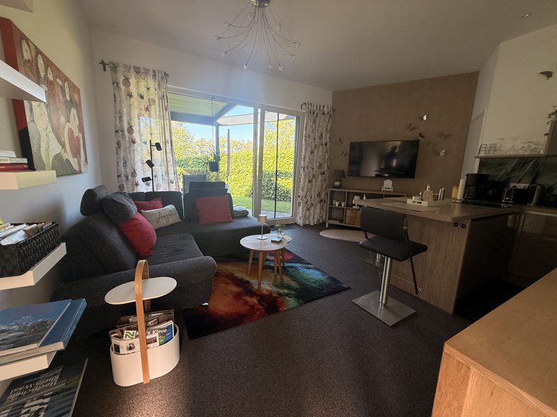 Wohnzimmer mit offener Küche und Gartenzugang